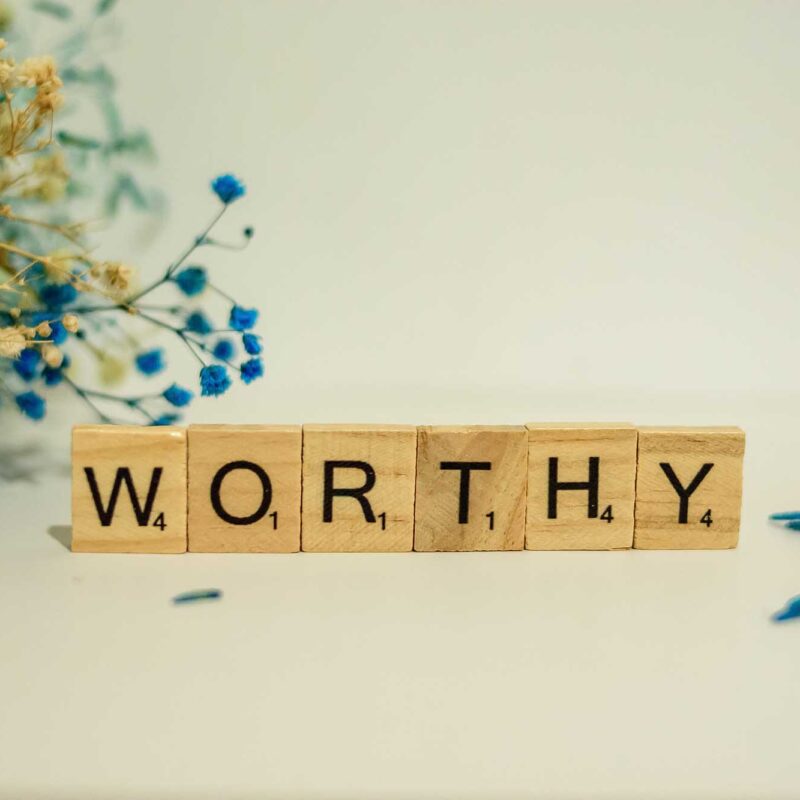 The word 'worthy' in scrabble letters