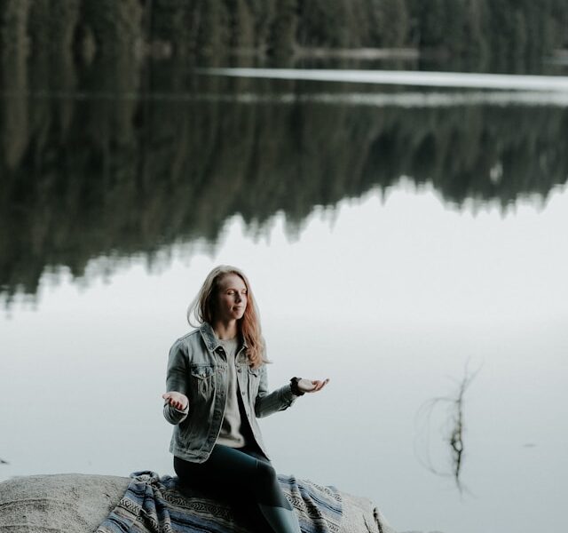 Peaceful woman praying by a lake