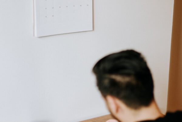 Man reading Bible with Calendar on the wall