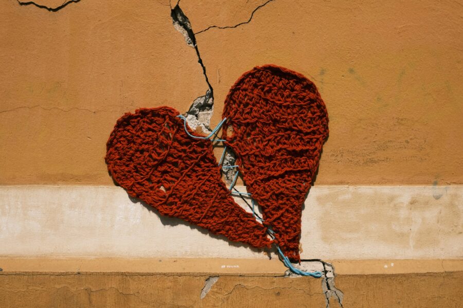 Knitted red heart in a wall