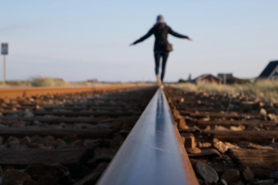 Figure balancing on a train line